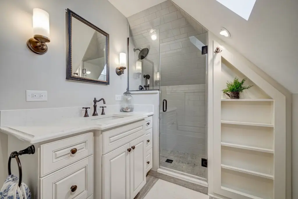 A shower area with white cabinets and sink